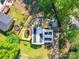 Aerial shot of the home's backyard, featuring a pool, deck, trampoline, and surrounding trees and greenery at 6820 Elm Forest Dr, Charlotte, NC 28212