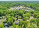 Aerial view of the property surrounded by mature trees, residential homes, and community buildings at 6820 Elm Forest Dr, Charlotte, NC 28212