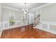 Elegant dining room with hardwood floors, decorative wainscoting, and a stylish chandelier at 6941 Augustine Way, Charlotte, NC 28270