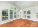 Bright dining room with hardwood floors and large windows offering serene backyard views at 6941 Augustine Way, Charlotte, NC 28270