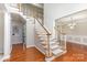 Grand foyer showcasing a staircase with wood railings and hardwood floors, leading to an open living space at 6941 Augustine Way, Charlotte, NC 28270