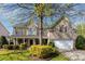 Inviting brick home with a covered porch, mature landscaping, and a two-car garage at 6941 Augustine Way, Charlotte, NC 28270