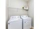 Functional laundry room with white appliances and shelving for storage at 6941 Augustine Way, Charlotte, NC 28270