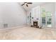Spacious living room featuring a stone fireplace, a ceiling fan, and lots of natural light at 6941 Augustine Way, Charlotte, NC 28270
