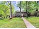 Traditional brick home with manicured lawn and garden, framed by mature trees at 7020 Leesburg Rd, Charlotte, NC 28215