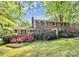 Charming brick two-story home with colorful flowers and a lush green lawn at 7020 Leesburg Rd, Charlotte, NC 28215