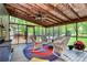 Screened porch with wicker furniture and a ceiling fan overlooking the lush backyard at 7020 Leesburg Rd, Charlotte, NC 28215