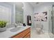 Bright bathroom with a white countertop, wood vanity, neutral wall color, and a glass-enclosed shower at 7067 Rocky Falls Rd, Charlotte, NC 28211