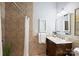 Bathroom featuring a walk-in shower with brown tile, a vanity with a dark wood cabinet, and a framed mirror at 7067 Rocky Falls Rd, Charlotte, NC 28211