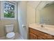 Well-lit bathroom with a wood vanity, white countertops, a commode, and a window with natural light at 7067 Rocky Falls Rd, Charlotte, NC 28211