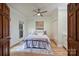 Cozy bedroom features neutral décor, hardwood floors, and a ceiling fan, creating a relaxing and inviting space at 7067 Rocky Falls Rd, Charlotte, NC 28211