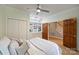 Bright bedroom with hardwood floors, built-in shelving, and closet storage for organization, plus white bedding at 7067 Rocky Falls Rd, Charlotte, NC 28211