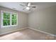Serene bedroom with neutral walls, carpet flooring, natural light from the window, and a ceiling fan, creating a calming retreat at 7067 Rocky Falls Rd, Charlotte, NC 28211