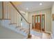 Inviting foyer with hardwood floors, a wooden staircase, and a decorative front door, creating a grand entrance at 7067 Rocky Falls Rd, Charlotte, NC 28211