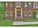 Classic brick home with a welcoming front entrance, manicured landscaping, and lawn at 7067 Rocky Falls Rd, Charlotte, NC 28211