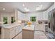 Well-lit kitchen featuring white cabinets, quartz countertops, stainless steel appliances and two skylights for bright light at 7067 Rocky Falls Rd, Charlotte, NC 28211