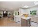 Bright kitchen with white cabinets and island open to living room with fireplace at 7067 Rocky Falls Rd, Charlotte, NC 28211
