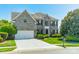 Charming gray brick two-story home with a well-manicured lawn, mature trees, and a two car garage at 709 Circle Trace Rd, Monroe, NC 28110
