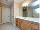 Neutral bathroom featuring a vanity with wooden cabinets, double sinks, and tile floor at 7409 Stonecroft Park Dr, Charlotte, NC 28226