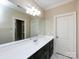 Bathroom with a large mirror, white countertop, and dark cabinets at 7409 Stonecroft Park Dr, Charlotte, NC 28226