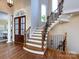 Grand foyer featuring hardwood floors, a staircase with iron railings, and an arched doorway at 7409 Stonecroft Park Dr, Charlotte, NC 28226