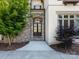 Close-up of the home's stone entryway with double front doors and manicured landscaping at 7409 Stonecroft Park Dr, Charlotte, NC 28226