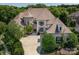 Elegant home with a combination of stone and stucco, complemented by mature landscaping and a circular driveway at 7409 Stonecroft Park Dr, Charlotte, NC 28226