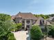 Elegant home with a combination of stone and stucco, complemented by mature landscaping and a circular driveway at 7409 Stonecroft Park Dr, Charlotte, NC 28226