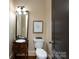 Elegant powder room with a furniture-style vanity, decorative mirror and convenient toilet at 7409 Stonecroft Park Dr, Charlotte, NC 28226
