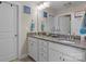 Bathroom with double sinks, granite countertop, framed mirror and white cabinets at 7693 Lazy Hollow Ln, Denver, NC 28037