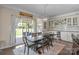 Bright dining area featuring a rustic wooden table and sliding glass doors to the backyard at 7693 Lazy Hollow Ln, Denver, NC 28037
