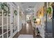 Inviting foyer with hardwood floors, paneled wainscoting, decorative accents and French doors at 7693 Lazy Hollow Ln, Denver, NC 28037