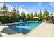 In-ground pool features a tanning ledge and water features and is surrounded by mature landscaping at 7693 Lazy Hollow Ln, Denver, NC 28037