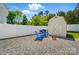 The backyard has a gravel area with chairs, a grill, a shed, and is surrounded by a white fence at 773 Sir Raleigh Dr, Concord, NC 28025