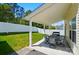 Covered patio with table and chairs overlooking fenced backyard with green grass at 773 Sir Raleigh Dr, Concord, NC 28025