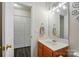 Bathroom with wood cabinets, large mirror, towel rack and an open door to linen closet at 773 Sir Raleigh Dr, Concord, NC 28025