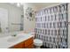 Bathroom features decorative wall art, colorful shower curtain, toilet, and vanity with wood cabinets at 773 Sir Raleigh Dr, Concord, NC 28025
