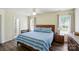 Bright bedroom with a wooden frame bed, ceiling fan, and natural light from two large windows at 773 Sir Raleigh Dr, Concord, NC 28025