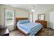 Comfortable bedroom featuring natural light, a ceiling fan, and stylish wood furnishings at 773 Sir Raleigh Dr, Concord, NC 28025