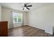 Bright bedroom features a ceiling fan, window with blinds and curtains, plus wood-look flooring at 773 Sir Raleigh Dr, Concord, NC 28025