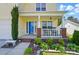 Charming covered front porch with brick accents, a seating area, and garden at 773 Sir Raleigh Dr, Concord, NC 28025
