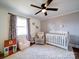 Charming Bedroom with hardwood floors, fresh paint, chair, and white crib at 8475 Nc 49 N Hwy, Mount Pleasant, NC 28124