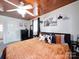 Bedroom featuring carpet floors, a wood plank ceiling, an orange comforter, and natural light from the window at 8475 Nc 49 N Hwy, Mount Pleasant, NC 28124