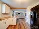 Eat-in kitchen features white cabinets, stainless appliances, a breakfast bar, and flows into the living room with hardwood floors at 8475 Nc 49 N Hwy, Mount Pleasant, NC 28124