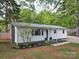 Charming single-story home featuring white siding, a metal roof, and a well-manicured front lawn at 8475 Nc 49 N Hwy, Mount Pleasant, NC 28124