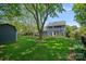 Spacious backyard with mature trees, manicured lawn, a shed, and a glimpse of the home's exterior at 8651 Walsham Dr, Charlotte, NC 28277