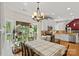 Bright dining area with a large window, hardwood floors, a chandelier, and a view to a kitchen with white cabinets at 8651 Walsham Dr, Charlotte, NC 28277