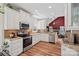 Open-concept kitchen featuring granite countertops, stainless steel appliances, white cabinetry, and hardwood floors at 8651 Walsham Dr, Charlotte, NC 28277