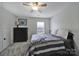 Comfortable bedroom with a gray comforter, a dark dresser, a ceiling fan, and a bright window at 901 Heritage Pkwy, Fort Mill, SC 29715