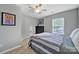 Neutral bedroom features a bed, a ceiling fan, dark dresser and bright window at 901 Heritage Pkwy, Fort Mill, SC 29715